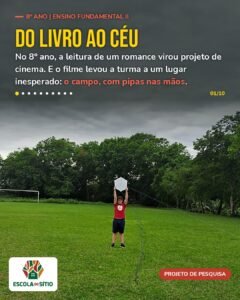 Estudante do 8º ano segura uma pipa branca no alto, no campo, sob céu nublado