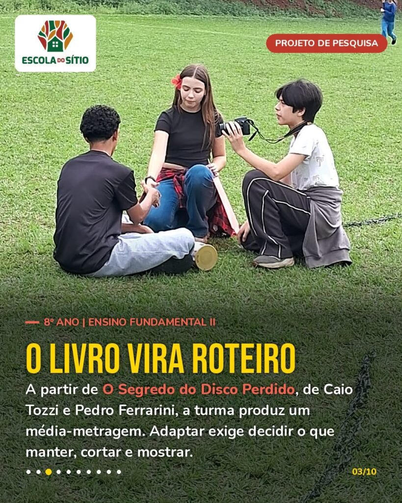 Três estudantes sentados na grama conferem a gravação na câmera durante a produção do média-metragem