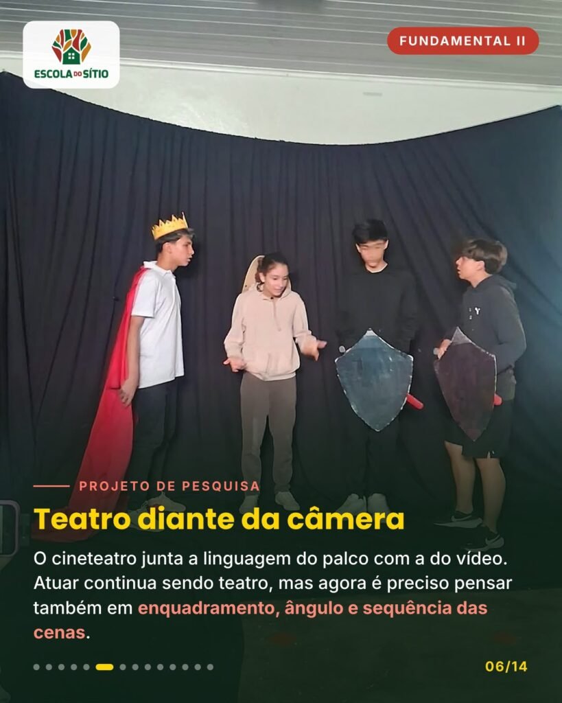 Estudantes com coroa, capa e escudos de papelão atuam diante da câmera