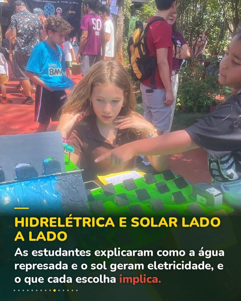Estudantes explicam as maquetes de hidrelétrica e de cidade com energia solar aos visitantes