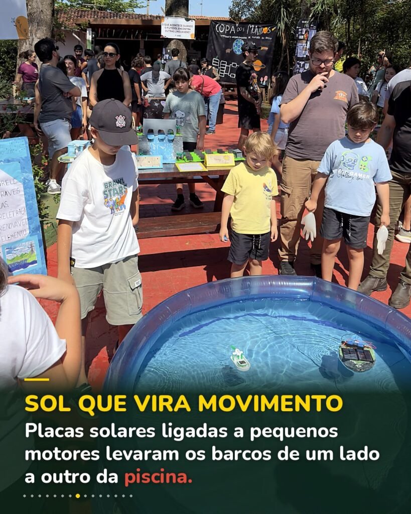 Barcos movidos a placa solar cruzam a piscina enquanto famílias e crianças observam